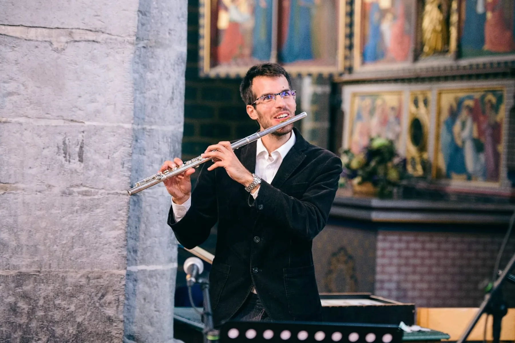 Damien jouant de la flûte traversière lors d'un concert